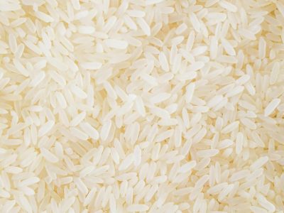 Close-up image of numerous white rice grains, showcasing texture and abundance.